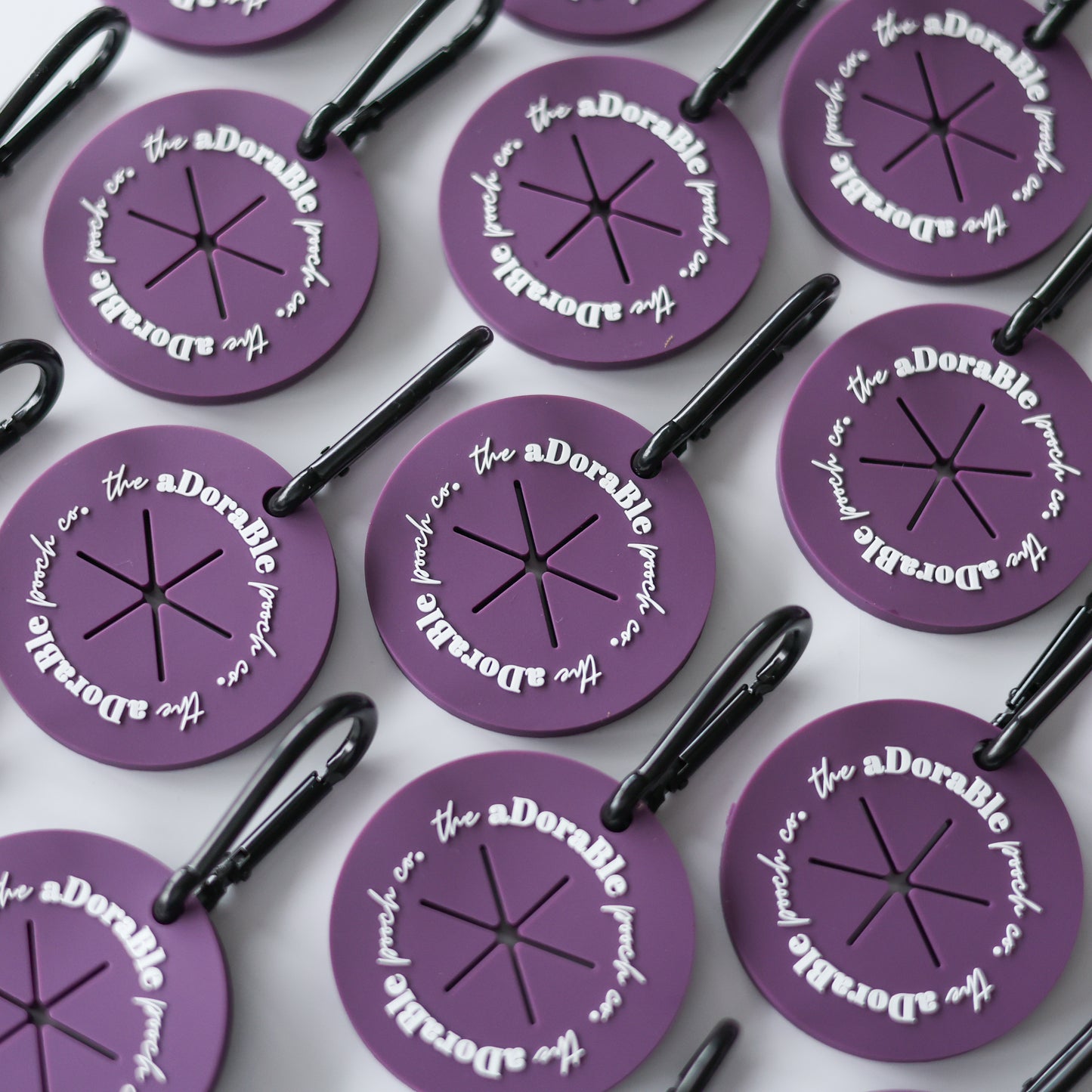 A flat lay of nine purple dog poop bag carriers