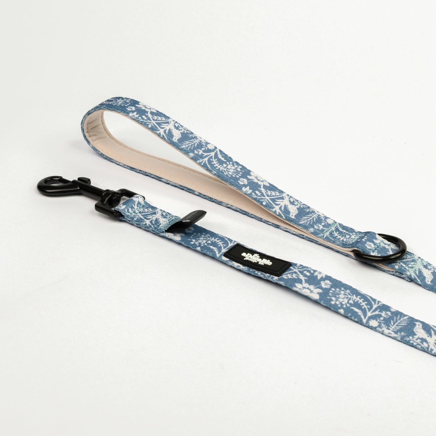 Blue and white floral patterned dog lead with black hardware on a white background