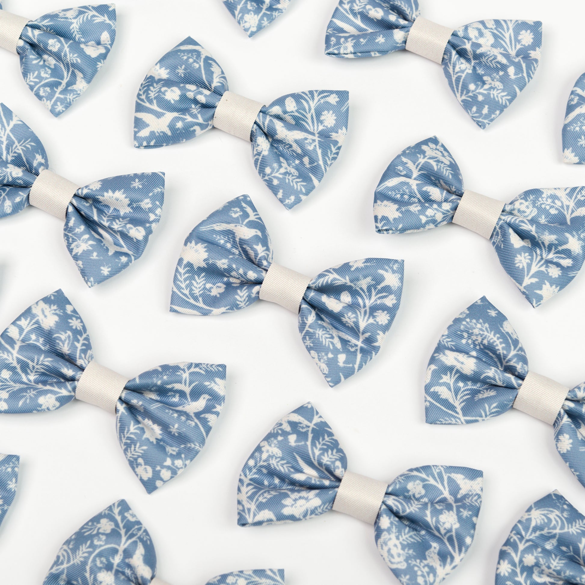 Pattern of blue and white Shepherd's Purse floral dickie bow ties for dogs on a white background