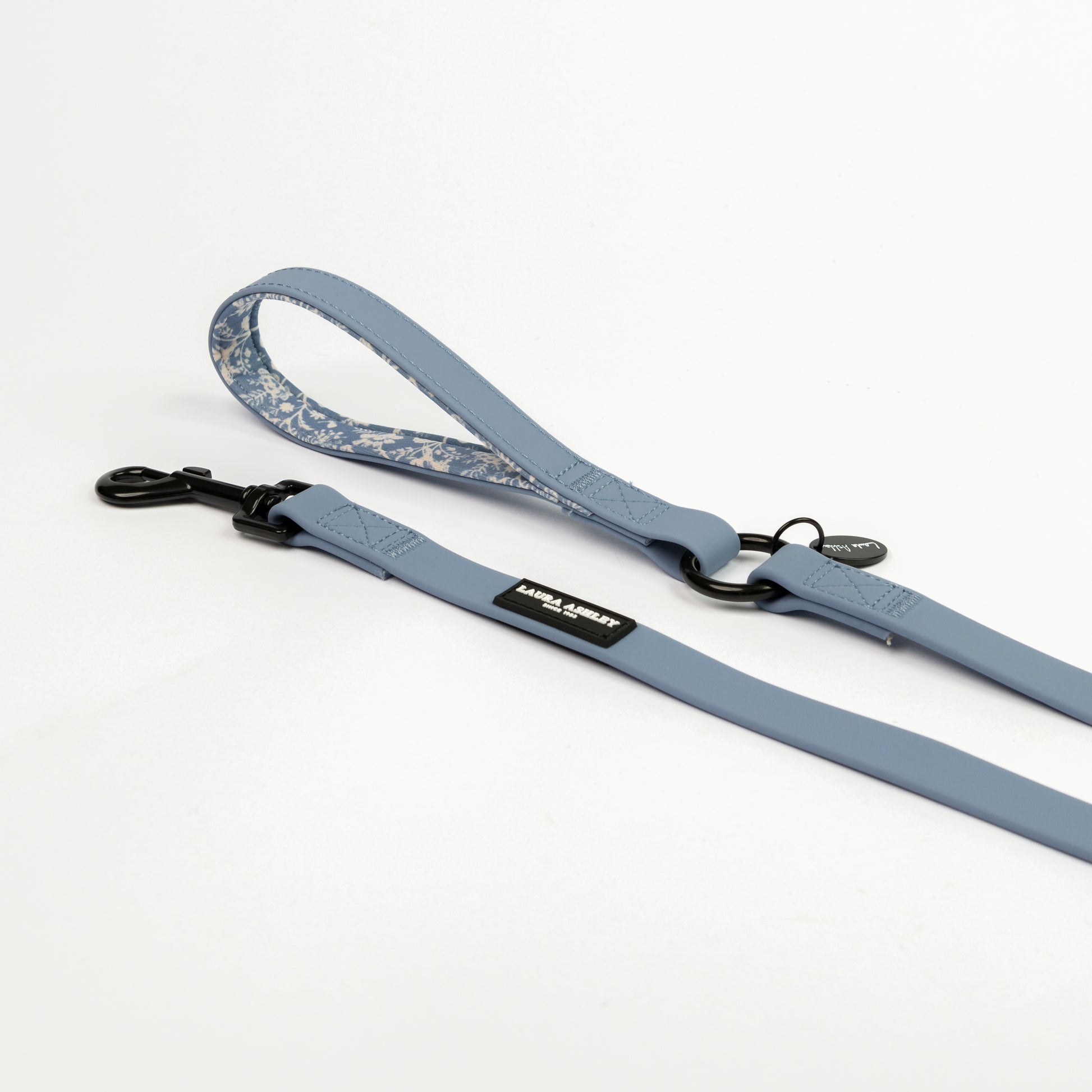 Blue dog leash with floral patterned handle laid  on a white background