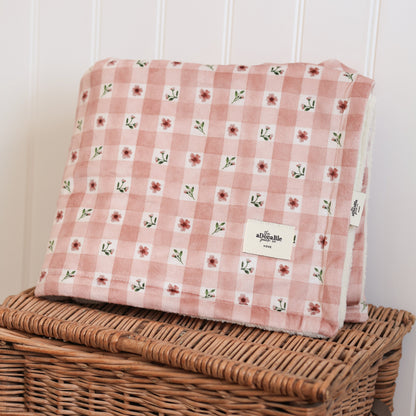 Floral-patterned cushion on a wicker basket against a white wall