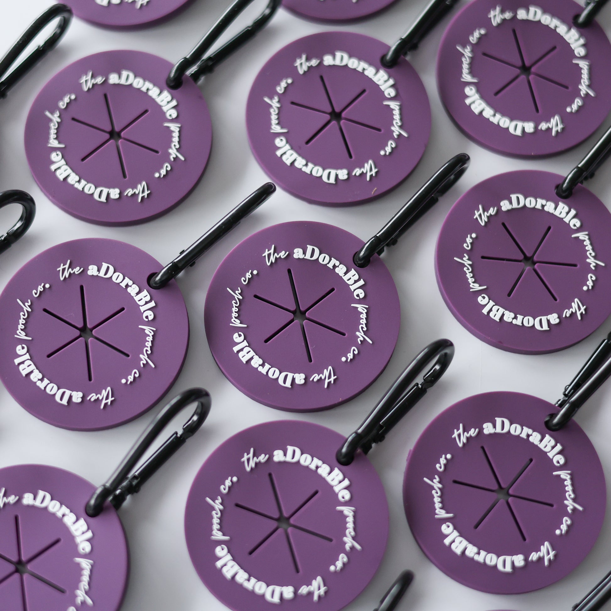 A flat lay of nine purple dog poop bag carriers