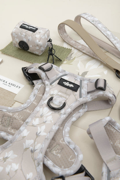 Dog waste bag dispenser in cream and white floral pattern with Laura Ashley label and hardware on a white background.