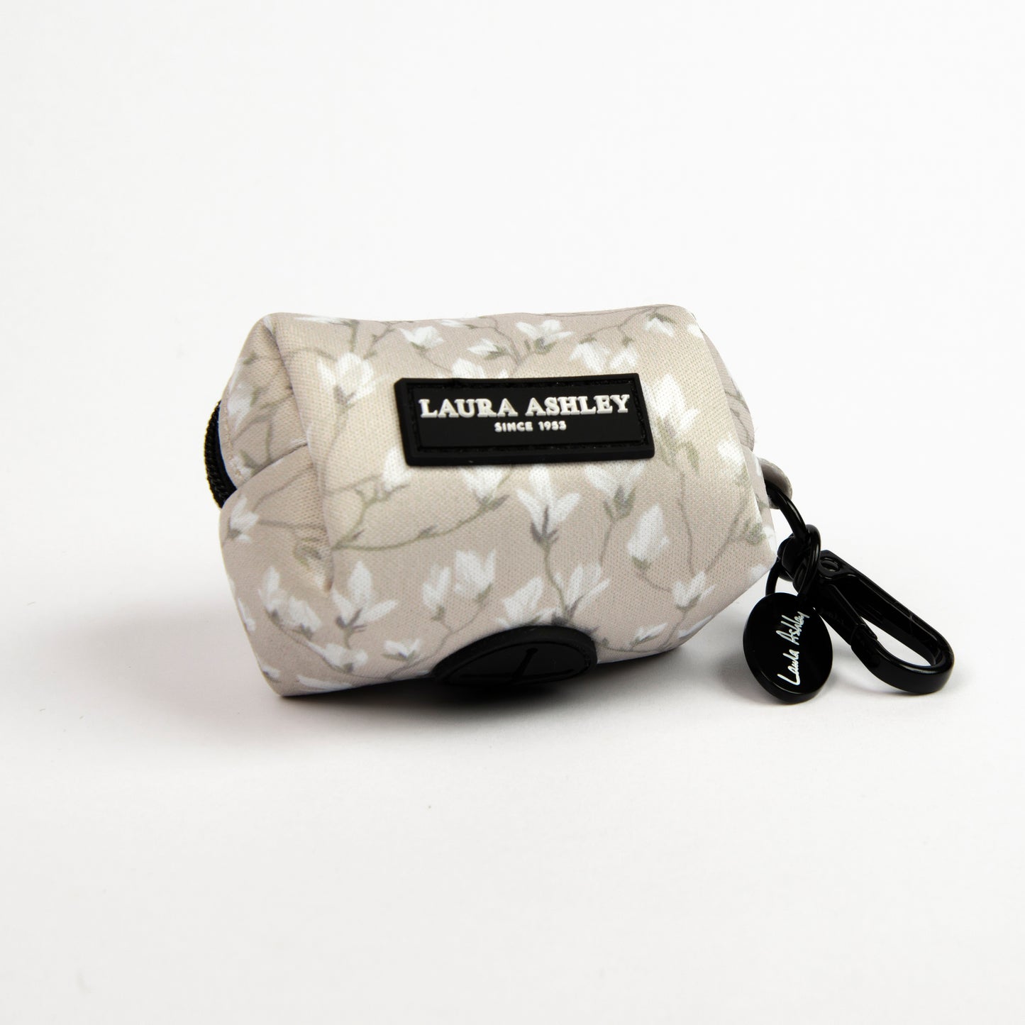 Dog waste bag dispenser in cream and white floral pattern with Laura Ashley label and hardware on a white background.