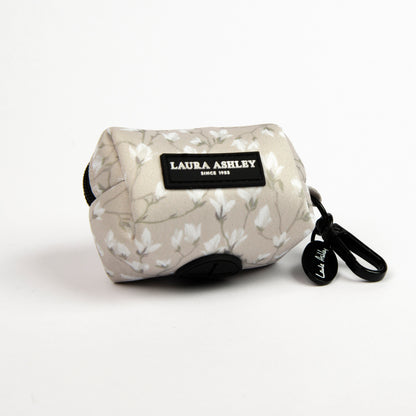 Dog waste bag dispenser in cream and white floral pattern with Laura Ashley label and hardware on a white background.